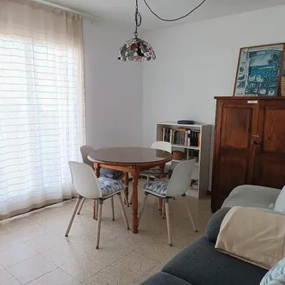 a table and chairs in a living room with a couch at Vivalidays Andrea - Pineda de Mar in Pineda de Mar