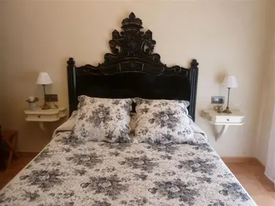 a bedroom with a large bed with a black headboard and pillows at Casa de pueblo con jardín in Premiá de Mar