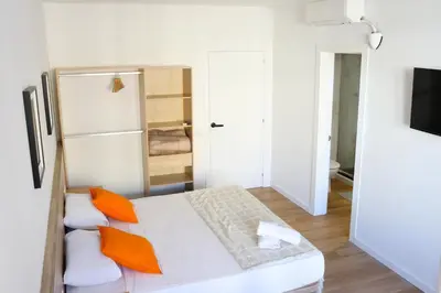 a small room with a bed and a refrigerator at Hamilton Suites in Barcelona