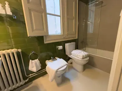 a bathroom with a toilet and a sink and a window at Ca La Manso in Sitges