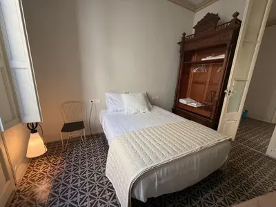 a bedroom with a bed and a wooden dresser at Ca La Manso in Sitges