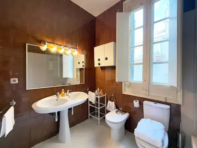 a bathroom with a sink and a toilet and a mirror at Ca La Manso in Sitges