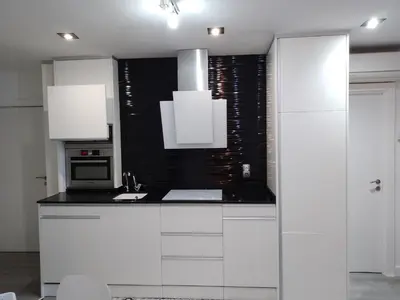 a white kitchen with white cabinets and a microwave at Sitges Oasis in Sitges