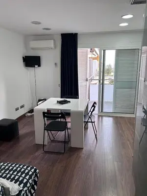 a living room with a white table and chairs at Mery Castelldefels Beach in Castelldefels