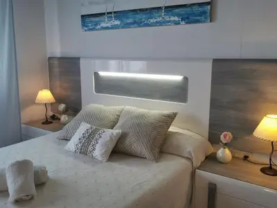 a bedroom with a bed with pillows and two lamps at Apartaments Mare Nostrum in Sitges