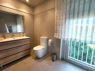 a bathroom with a toilet and a sink and a window at Exclusive Beach District Flat - Fully Renovated in Barcelona