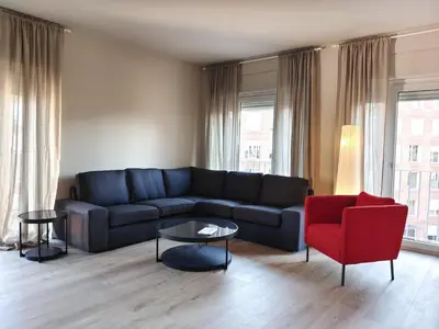 a living room with a blue couch and a red chair at Exclusive Beach District Flat - Fully Renovated in Barcelona