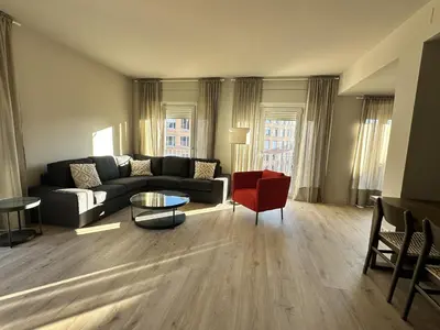 a living room with a couch and a red chair at Exclusive Beach District Flat - Fully Renovated in Barcelona