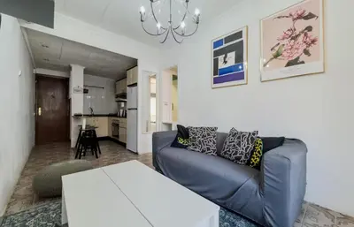a living room with a couch and a table at Apartamento en Barcelona Pau sans in Hospitalet de Llobregat