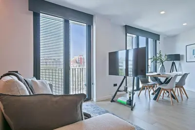 a living room with a television and a table with chairs at 3 Bedroom Cozy Apartment In Joan Austria in Barcelona