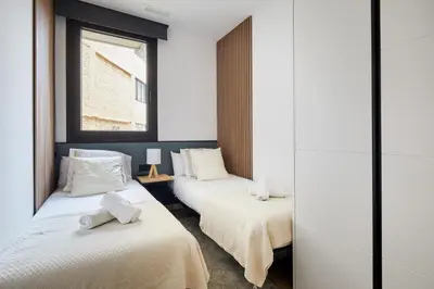 a room with two beds with towels on them at 3 Bedroom Cozy Apartment In Joan Austria in Barcelona