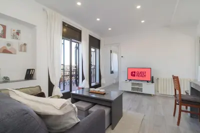 a living room with a couch and a tv at Guest Ready‑Bright & Stylish Flat with 3 Terraces in Barcelona