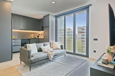 a living room with a couch and a kitchen at 1 Bedroom Cozy Aparment Joan Austria in Barcelona