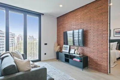a brick wall in a living room with a tv at 1 Bedroom Cozy Aparment Joan Austria in Barcelona