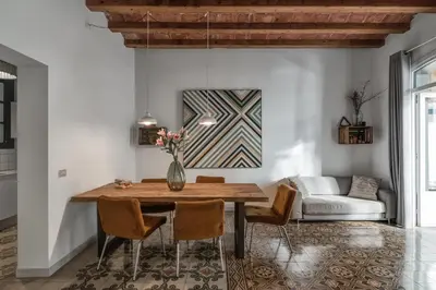 a dining room with a table and chairs and a couch at Brummell Apartments Eixample Derecha/Ballroom in Barcelona