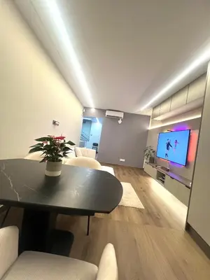 a living room with a table and a tv at Beautiful duplex apartment in center Barcelona in Barcelona