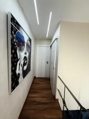 a hallway with a staircase with black and white pictures on the wall at Beautiful duplex apartment in center Barcelona in Barcelona
