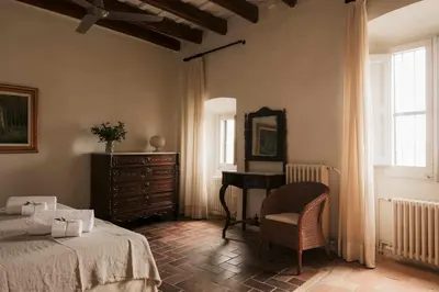 a living room with a chair and a staircase at Ca l'Andreu Ecoturisme in Tiana