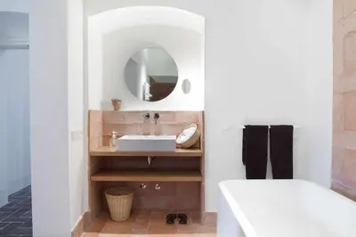 a bathroom with a sink and a tub and a mirror at Ca l'Andreu Ecoturisme in Tiana
