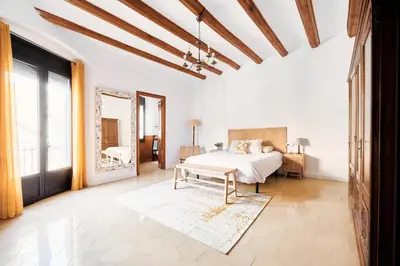 a bedroom with a white bed and a large window at Apartamento en Caldes d'Estrac in Caldes d'Estrac