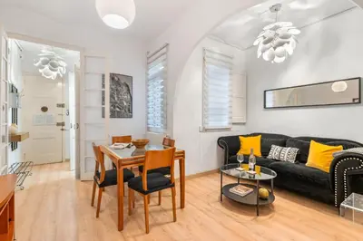 a living room with a black couch and a table at Whisper-Quiet 2BR Near Sagrada in Barcelona