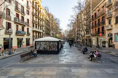 a group of people sitting on benches on a city street at Whisper-Quiet 2BR Near Sagrada in Barcelona