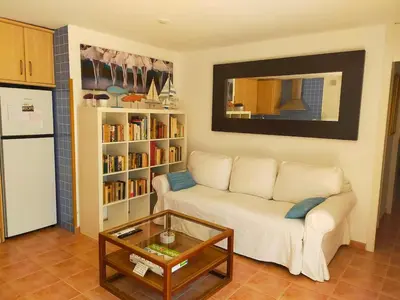 a living room with a white couch and a coffee table at Lovely little house with garden in Sant Vicenç de Montalt