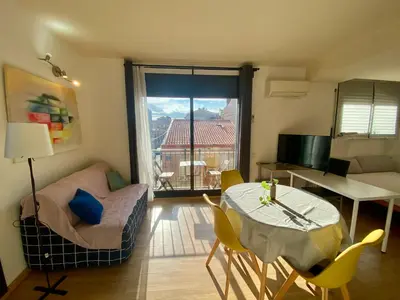 a living room with a table and a dining room at Loft muy soleado en Terrassa in Terrassa