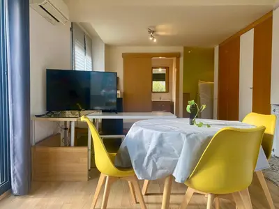 a dining room with a table and yellow chairs at Loft muy soleado en Terrassa in Terrassa