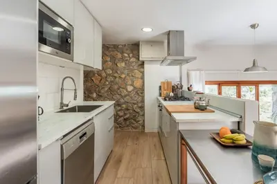 a kitchen with white cabinets and a counter top at Casa Olivella #7 by Happy Houses Barcelona in Olivella