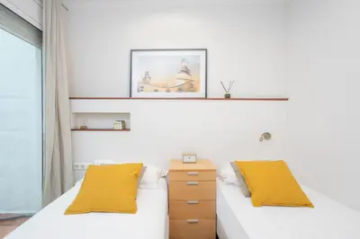 a bedroom with two beds and a picture on the wall at Canela Homes BARCELONA MERCÈ in Barcelona