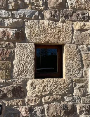 a small window in a stone wall at Cal correu Hort - Xida in Collsuspina