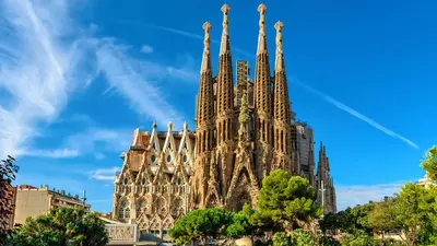 a large building with tall spires on a blue sky at Ven una temporada al centro de Barcelona in Barcelona