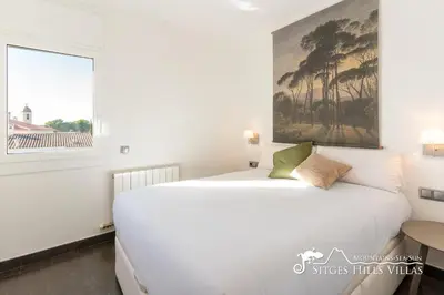 a kitchen with white cabinets and a black counter top at Modern Apartment Lily close to beach with Com Pool and AC in Sitges