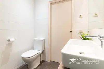 a white bathroom with a toilet and a sink at Modern Apartment Lily close to beach with Com Pool and AC in Sitges