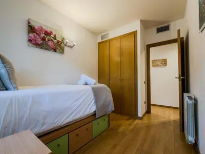 a bedroom with a bed and a wooden door at Bed BCN Vila Olímpica. in Barcelona