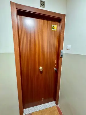 a wooden door in a room with a sign on it at Apartamento Lauda 2 in Hospitalet de Llobregat