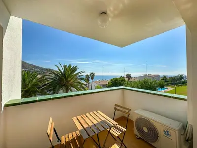 a balcony with a bench and a table and a fan at Viva Palms by Hello Homes Sitges in Sitges