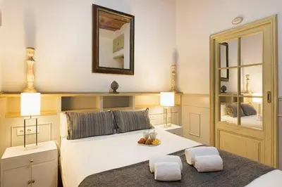 a bedroom with a white bed and a mirror at Romantic in Trendy Gracia in Barcelona