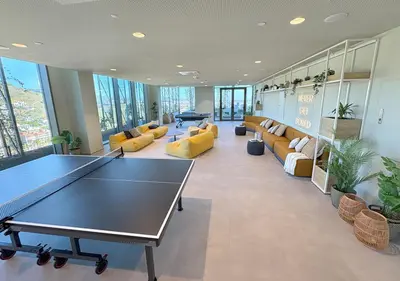 a room with a ping pong table and couches at aparto Diagonal Suites in Esplugues de Llobregat