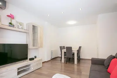 a living room with a couch and a table with chairs at Dialez Holidays - Sant Nicasi in Gavà