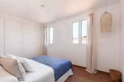 a white bedroom with a bed and a window at Casa Rosari I - Jardín & Parking Privado in Vilassar de Mar