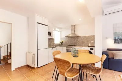 a kitchen and dining room with a table and chairs at Casa Rosari I - Jardín & Parking Privado in Vilassar de Mar