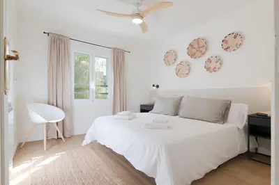 a white bedroom with a white bed and a window at Rosari II - Vivienda Privada con Parking in Vilassar de Mar