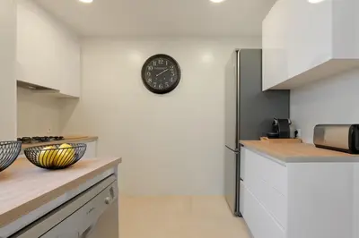 a kitchen with a clock on the wall at Rosari II - Vivienda Privada con Parking in Vilassar de Mar
