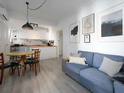 a living room with a blue couch and a table at Cosy Sants Apartment in Barcelona