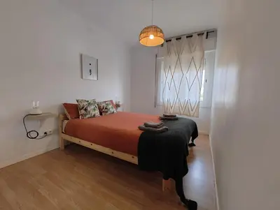 a bedroom with a bed with orange sheets and a window at Apartamento en Montgat - Serenity Stays in Montgat