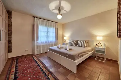 a bedroom with a large bed and a window at LuxRural Montserrat | Piscina con Vistas Únicas in Marganell
