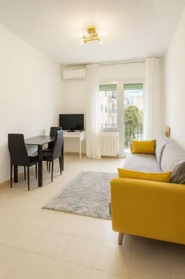 a living room with a yellow couch and a table at New renovate apartment near of the sea in Barcelona