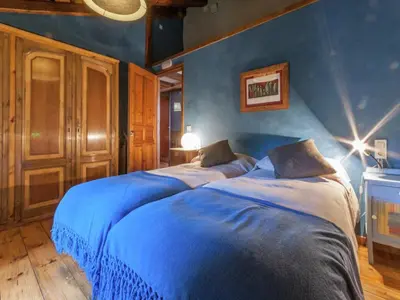 two beds in a bedroom with blue walls at Farmhouse near Barcelona with Pool in Marganell